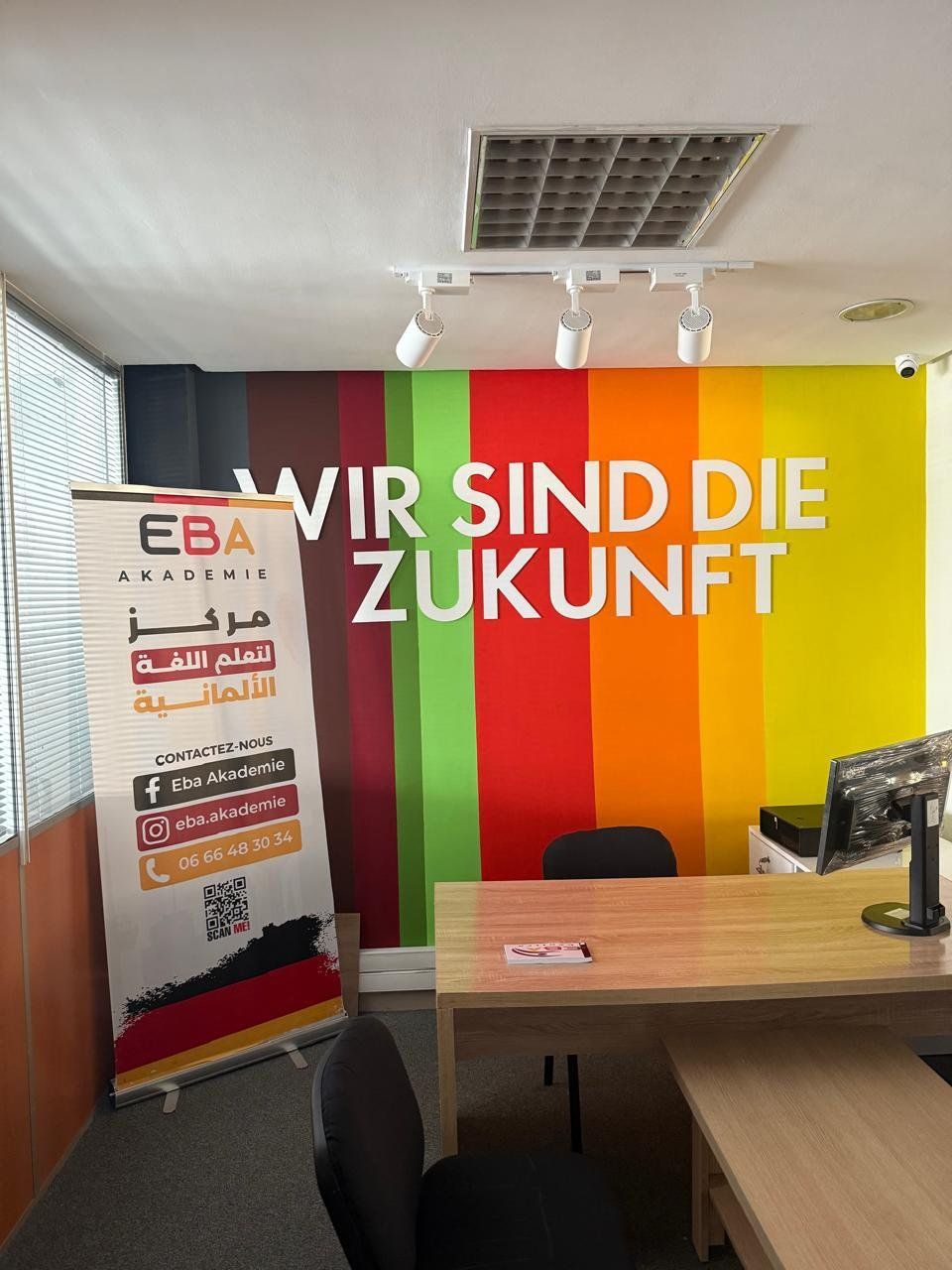 Bureau d’accueil d’un centre EBA Akademie, devant la fresque « Wir sind die Zukunft »